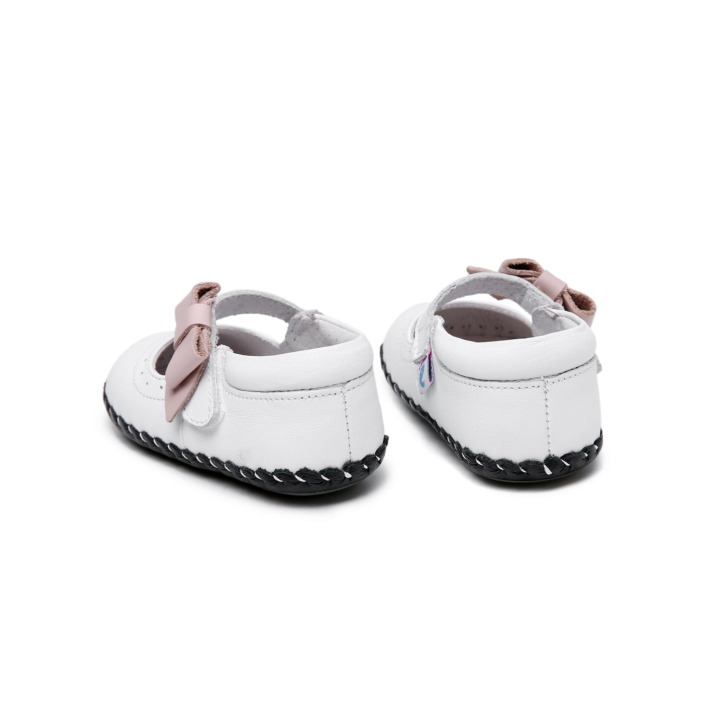 white girls' shoes in Mary Jane style with a soft pink bow accent and adjustable velcro closure made from genuine leather