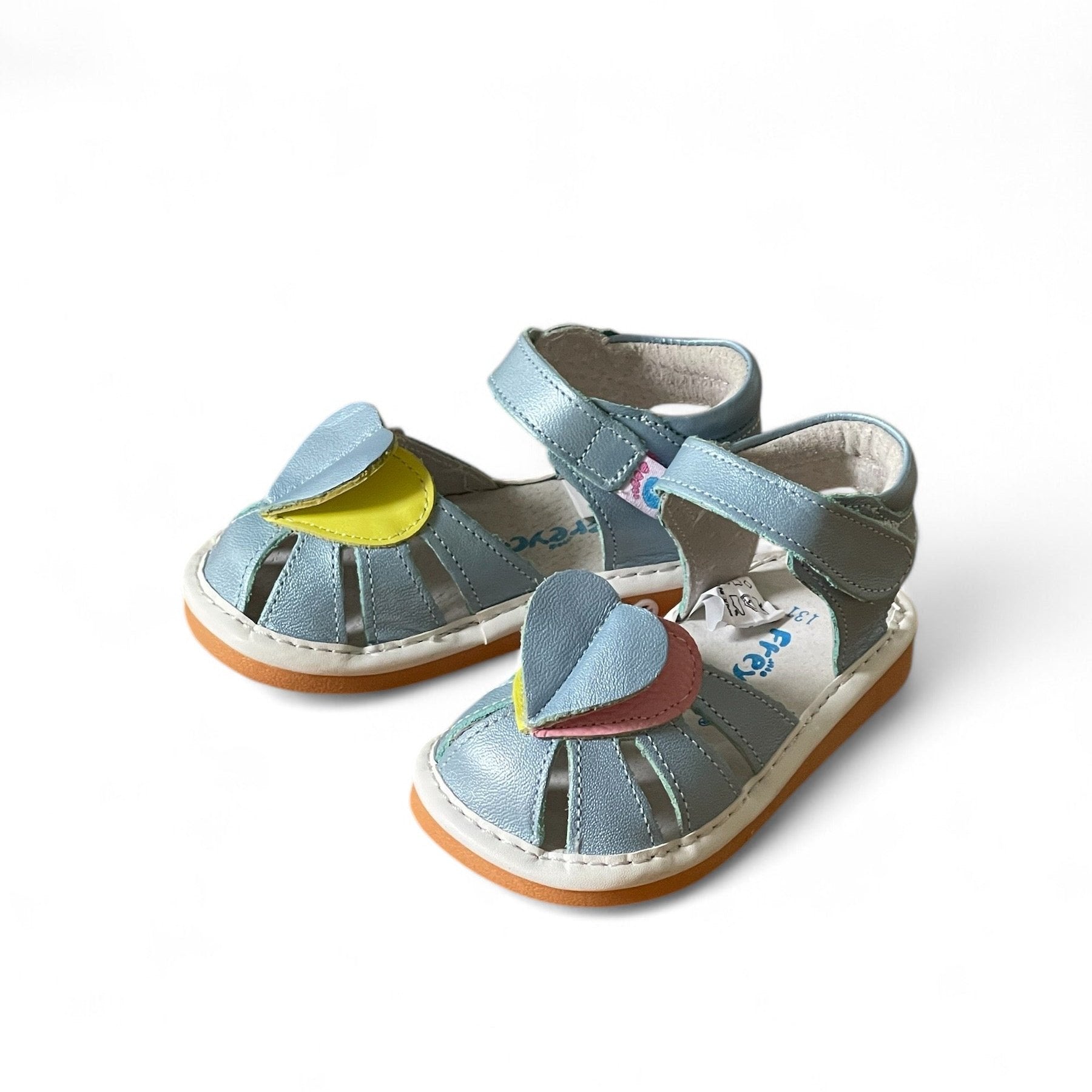 Light blue kids' sandals with colorful pink and yellow leaf-shaped straps and Velcro closures