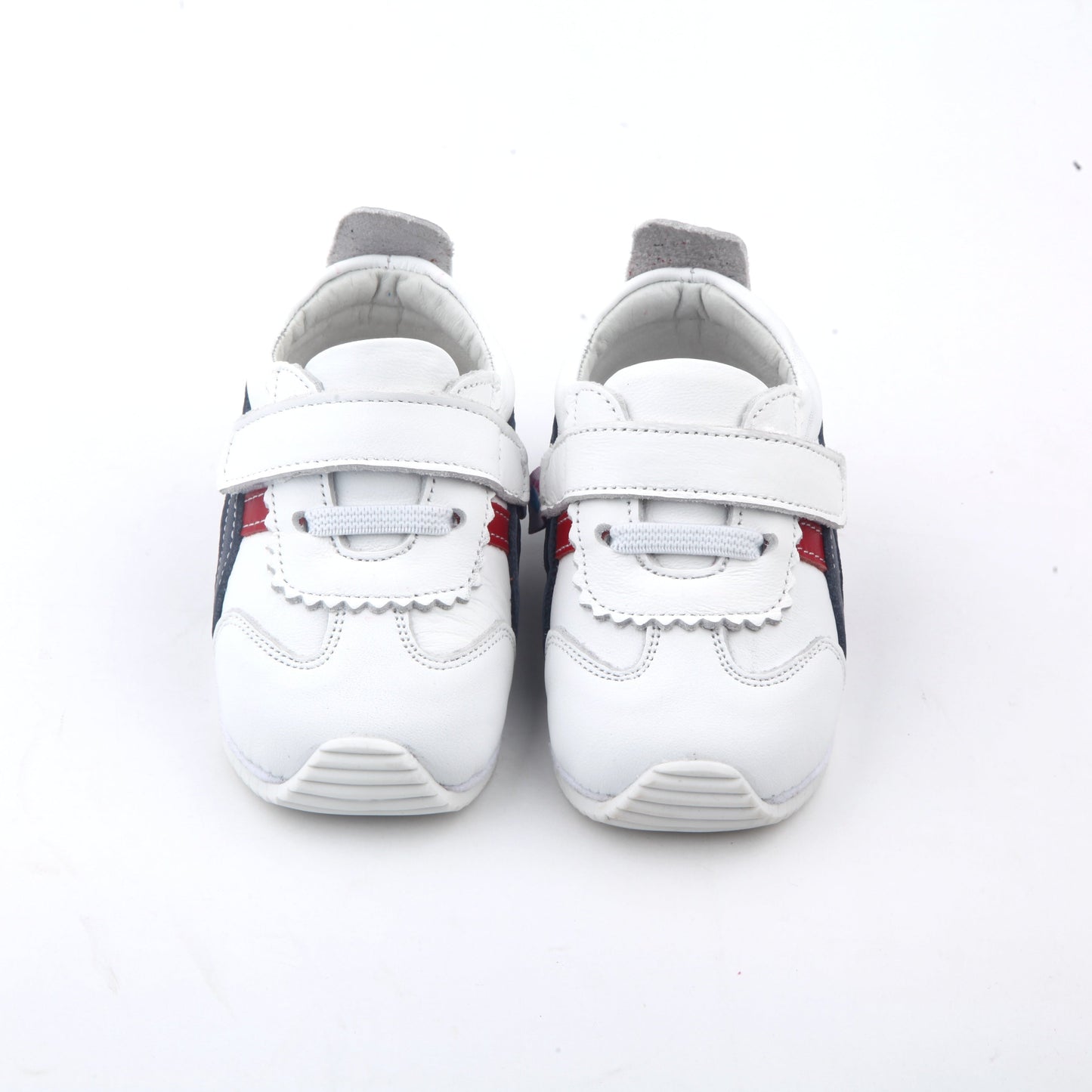 white kids sneakers with blue and red side stripes and velcro straps
